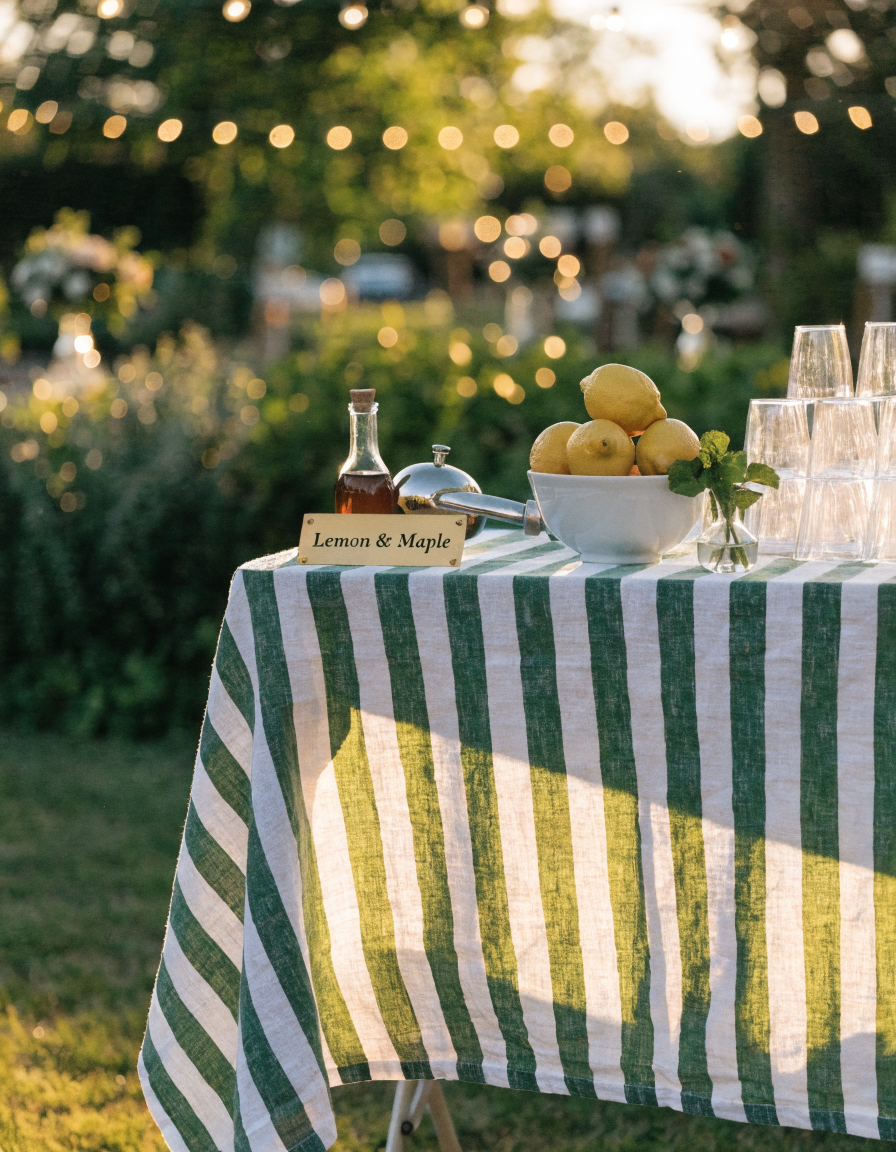 Lemon & Maple wedding table with striped linen, bowl of lemons, and maple syrup at golden hour